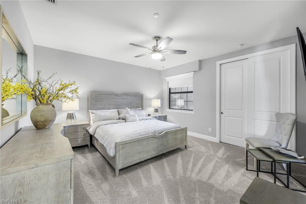 9641 Montelanico Loop, Unit 103 Naples, FL 34119 - Photo 15 of 28 a bedroom with a bed and chair