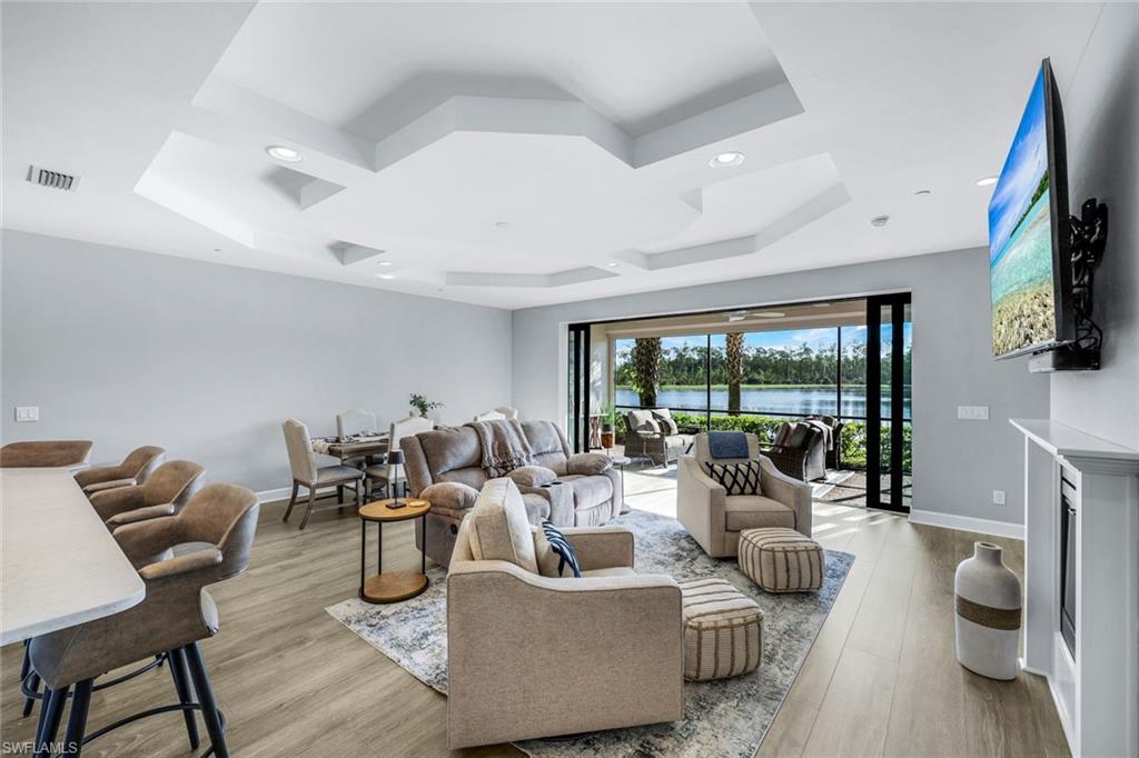 9641 Montelanico Loop, Unit 103 Naples, FL 34119 - Photo 4 of 28 a living room with furniture and a flat screen tv