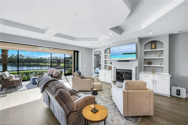a living room with furniture a fireplace and a floor to ceiling window