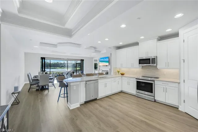 a kitchen with white cabinets and black stainless steel appliances