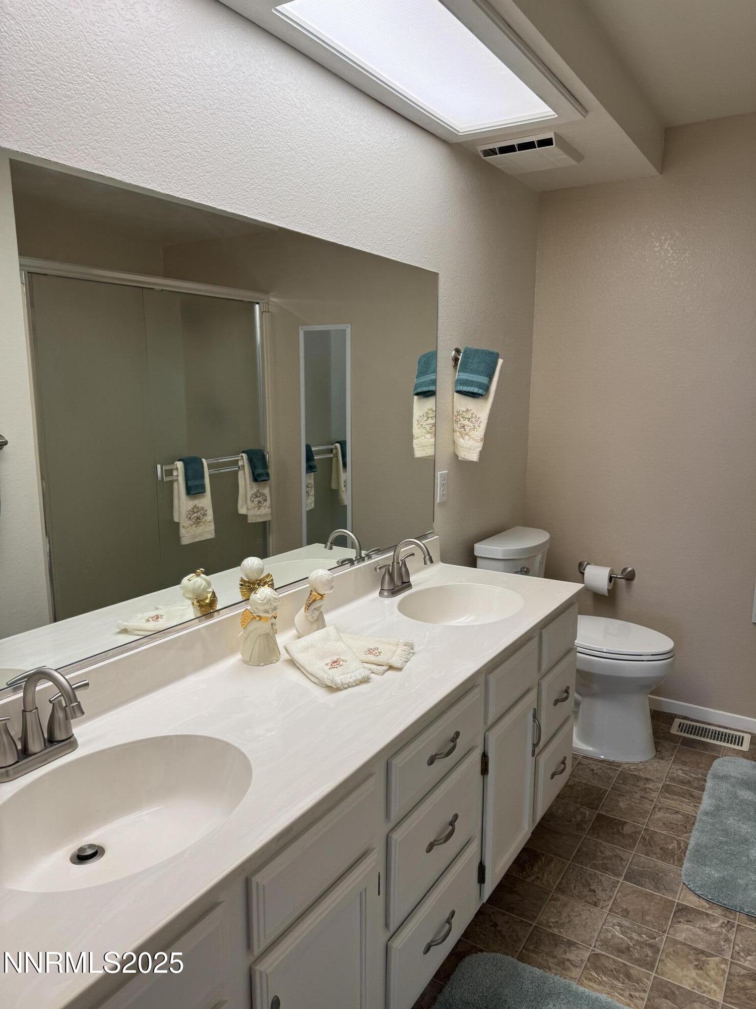 3016 Hauser Court Carson City, NV 89701 - Photo 2 of 13 a bathroom with a granite countertop sink mirror and toilet