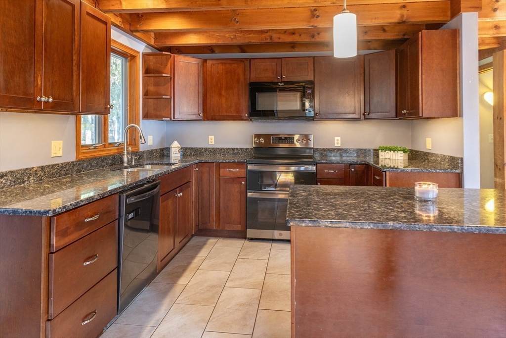 526 Station Road Amherst, MA 01002 - Photo 3 of 42 a kitchen with stainless steel appliances granite countertop a stove a sink and a microwave