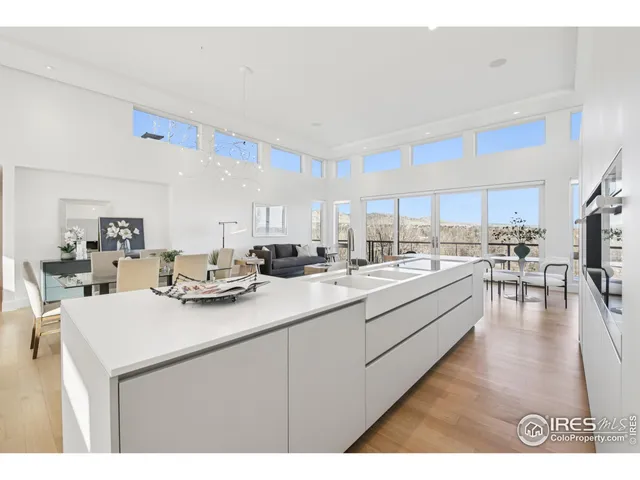 a kitchen with a sink a counter top space and living room area