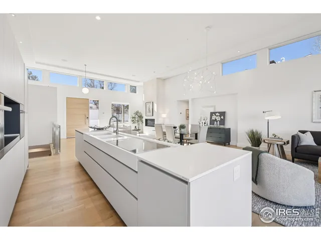 a large white kitchen with a sink and a refrigerator