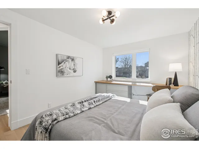 a living room with a bed furniture and painting on the wall