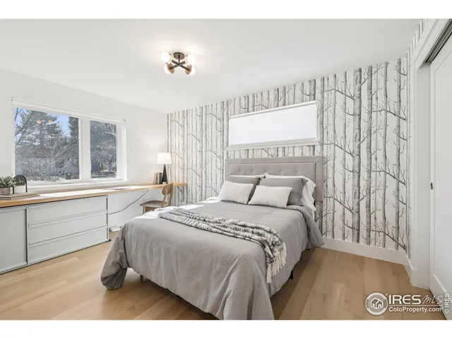 a bedroom with a bed and a large window