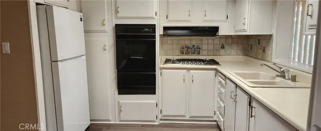 a kitchen with a refrigerator sink and cabinets