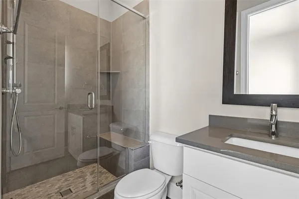a bathroom with a granite countertop sink toilet and shower