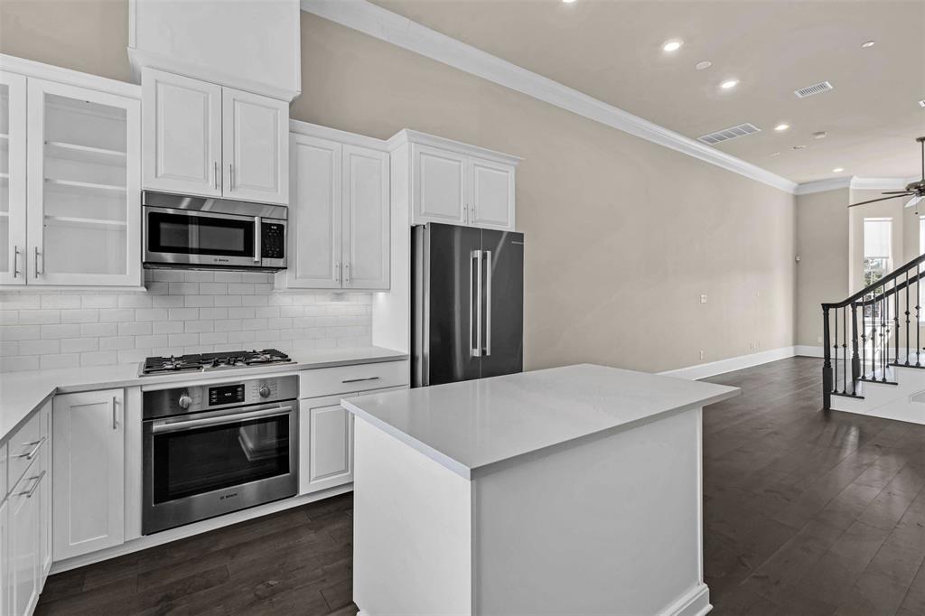 2238 Alterbrook Lane Dallas, TX 75219 - Photo 4 of 19 a kitchen with granite countertop a stove a microwave a refrigerator a sink and dishwasher with wooden floor