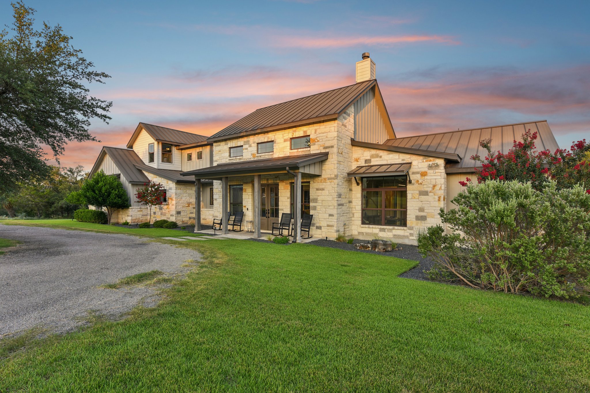 2203 Improver Road Spicewood, TX 78669 - Photo 10 of 38 A striking exterior combines stone and modern rooflines under a vibrant sky.