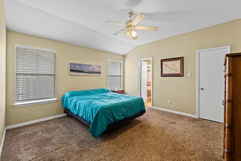 a spacious bedroom with a bed and a chandelier