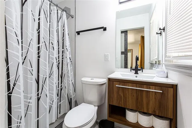 a bathroom with a toilet a sink and a mirror