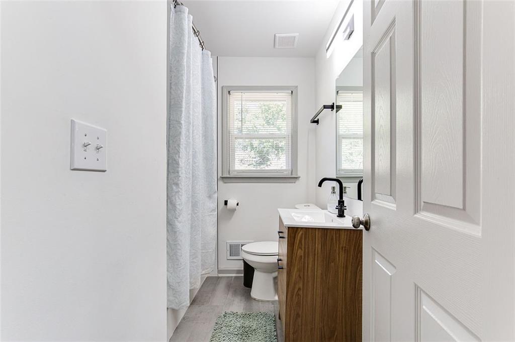 1300 Wichita Drive Southwest Atlanta, GA 30311 - Photo 9 of 10 a bathroom with a granite countertop sink toilet and mirror