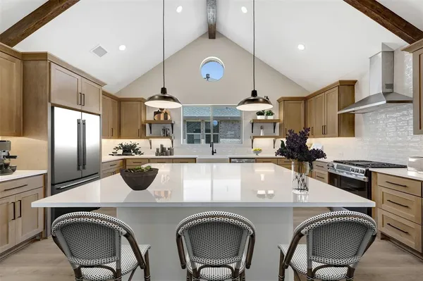 a large kitchen with stainless steel appliances lots of counter space and a sink