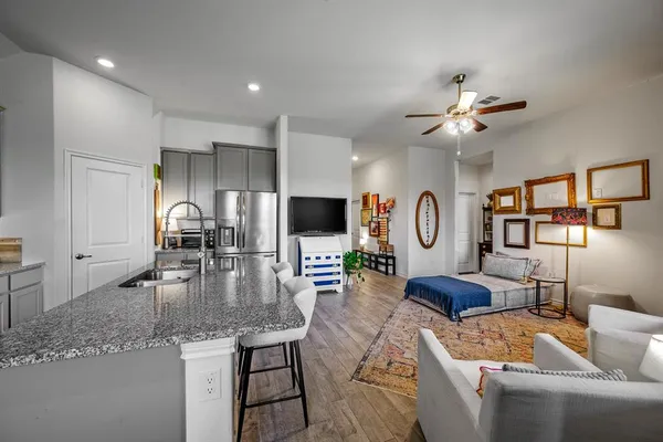a living room with furniture a flat screen tv and kitchen view