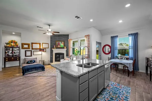 a kitchen with stainless steel appliances kitchen island granite countertop a stove refrigerator and cabinets