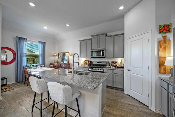 a kitchen with sink refrigerator dining table and chairs
