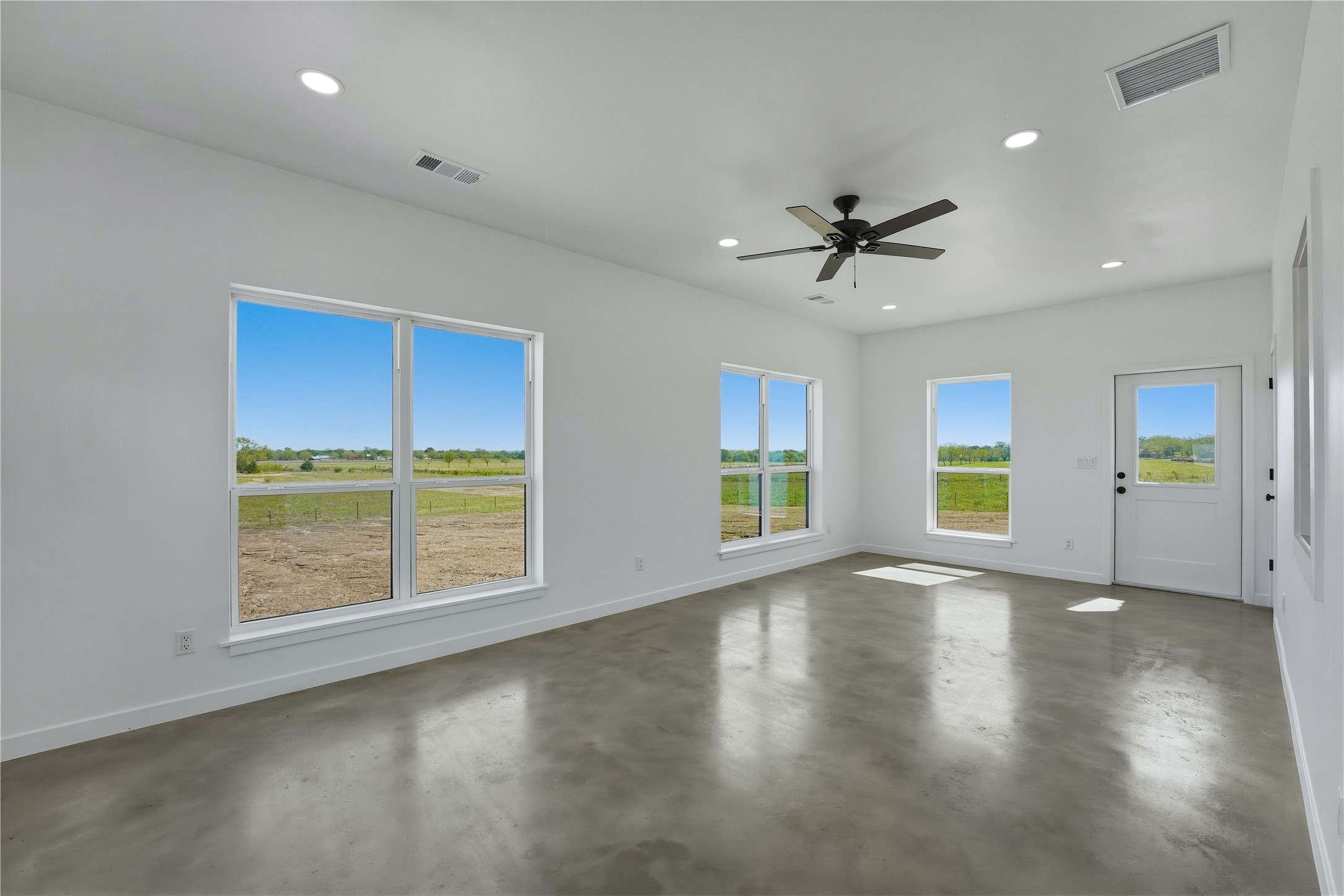 9391 Hajovsky Road La Grange, TX 78945 - Photo 12 of 22 an empty room with chandelier fan and windows