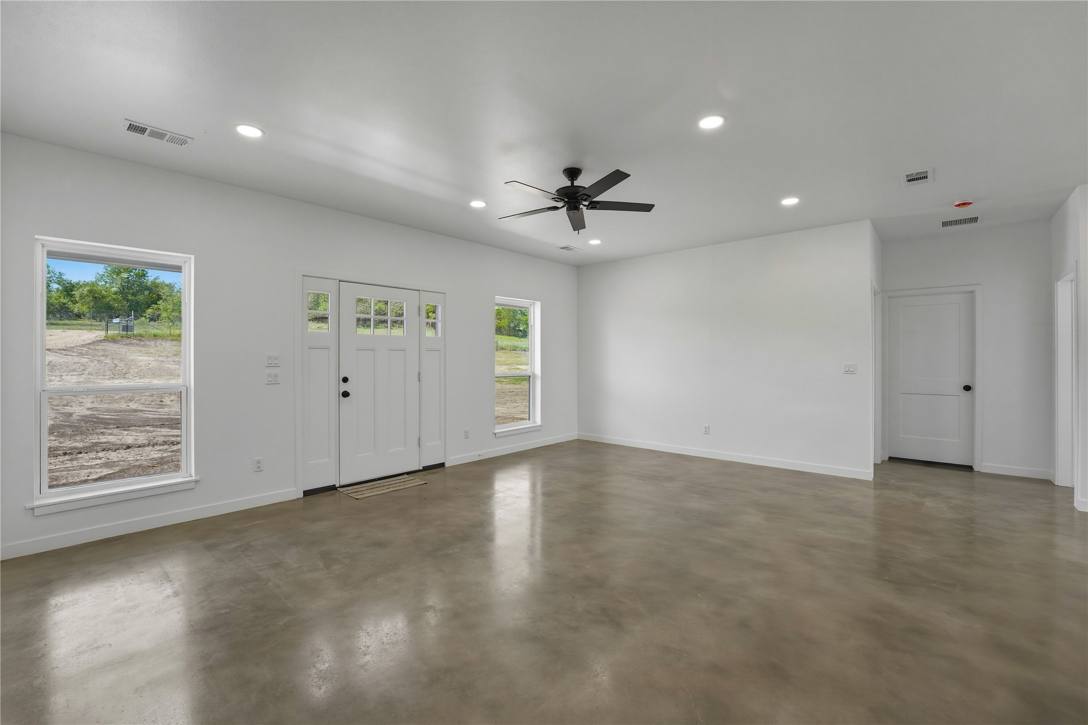 9391 Hajovsky Road La Grange, TX 78945 - Photo 5 of 22 an empty room with windows and ceiling fan