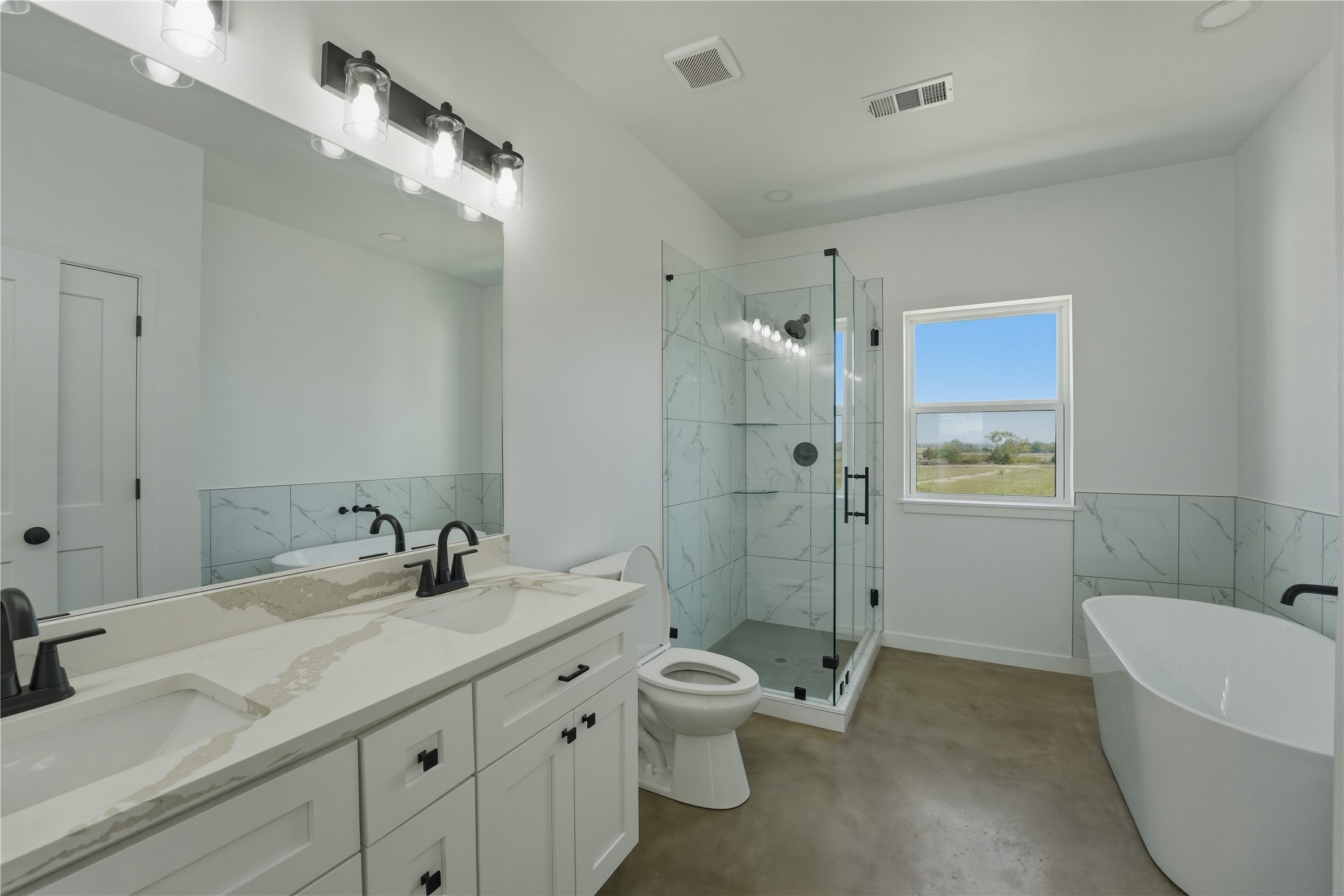 9391 Hajovsky Road La Grange, TX 78945 - Photo 6 of 22 a bathroom with a granite countertop toilet a sink and a bathtub