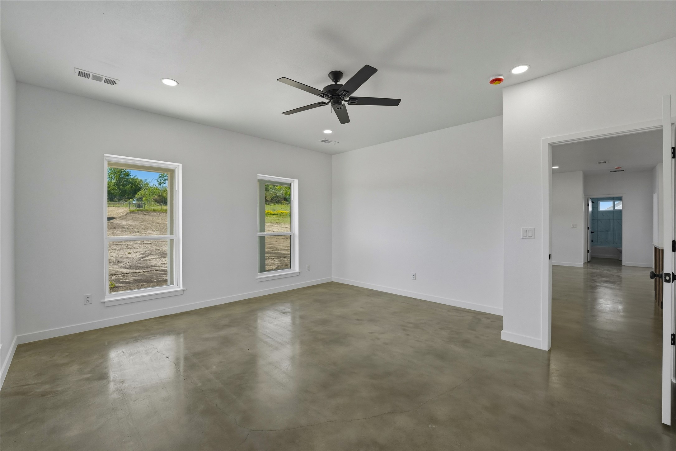 9391 Hajovsky Road La Grange, TX 78945 - Photo 8 of 22 an empty room with windows and ceiling fan