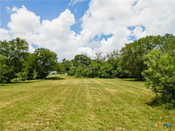 a view of a big yard with lots of green space