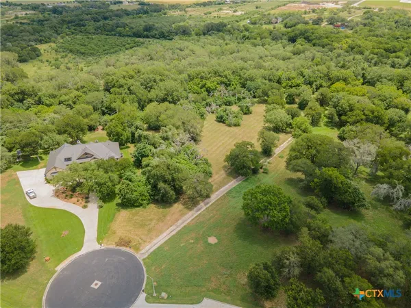 an aerial view of a house with a yard and lake view