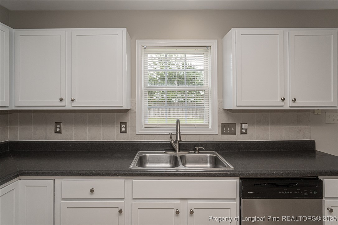 273 St George Drive Raeford, NC 28376 - Photo 11 of 38 a kitchen with stainless steel appliances granite countertop white cabinets sink and window
