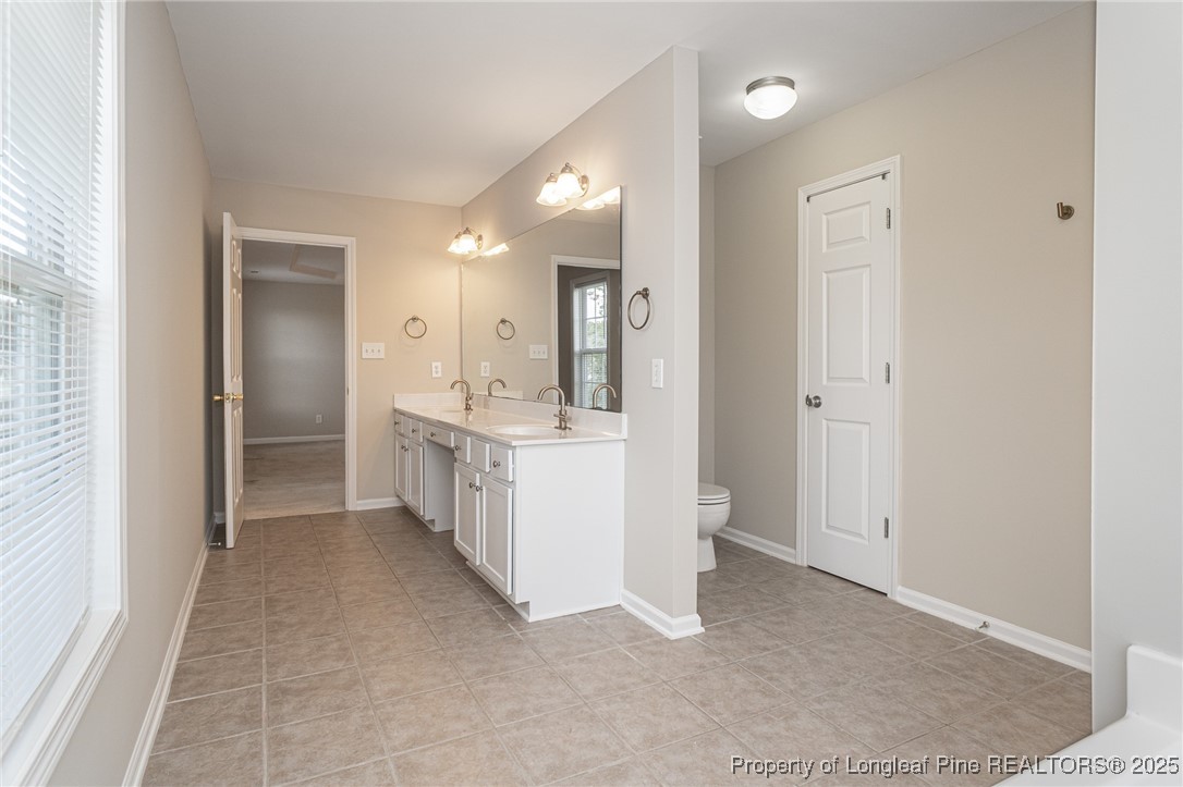 273 St George Drive Raeford, NC 28376 - Photo 23 of 38 a bathroom with a double vanity sink a mirror and a bathtub