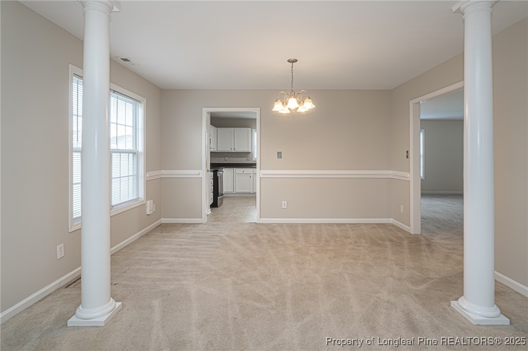 273 St George Drive Raeford, NC 28376 - Photo 6 of 38 an empty room with chandelier fan and kitchen view