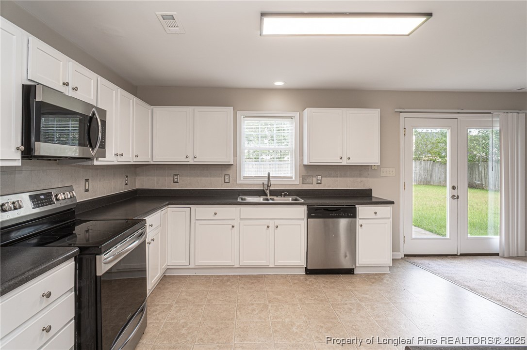 273 St George Drive Raeford, NC 28376 - Photo 9 of 38 a kitchen with stainless steel appliances granite countertop a stove a sink and a microwave