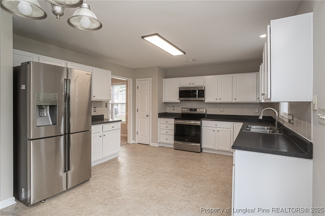273 St George Drive Raeford, NC 28376 - Photo 10 of 38 a kitchen with granite countertop a refrigerator oven a sink and dishwasher