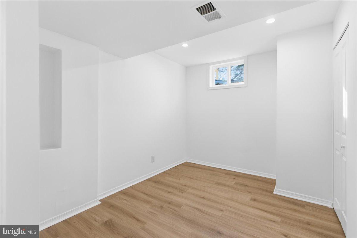 9409 Silver Fox Turn Clinton, MD 20735 - Photo 25 of 33 an empty room with wooden floor and windows