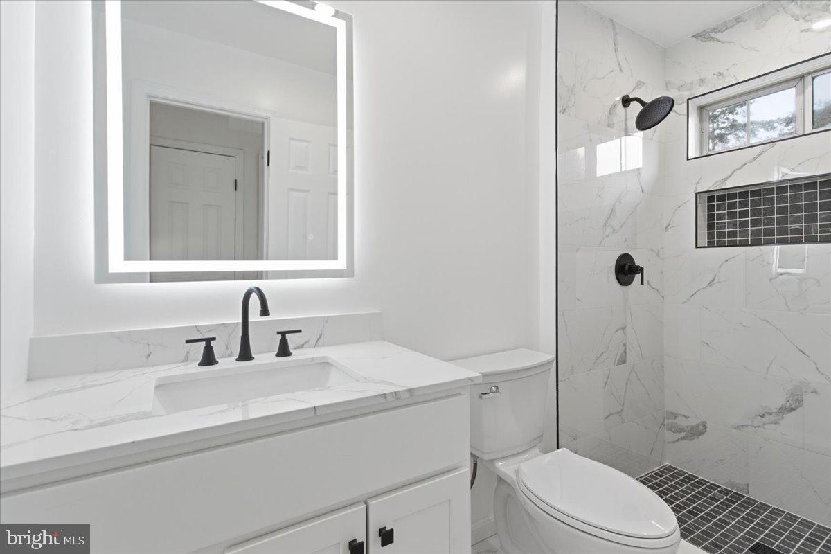 9409 Silver Fox Turn Clinton, MD 20735 - Photo 28 of 33 a bathroom with a sink toilet vanity and shower