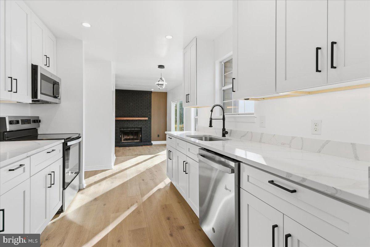 9409 Silver Fox Turn Clinton, MD 20735 - Photo 9 of 33 a kitchen with granite countertop kitchen island a sink stainless steel appliances and cabinets