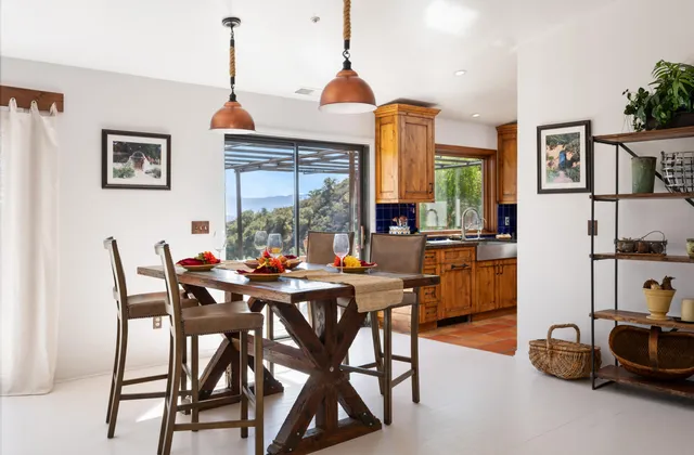 a kitchen with stainless steel appliances wooden floor and a large window