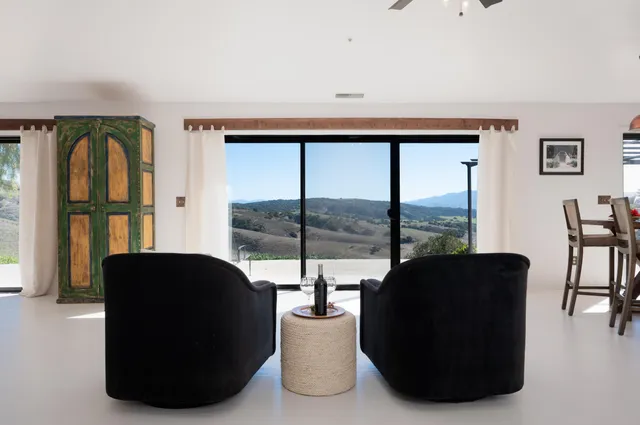 a living room with furniture large window and flat screen tv