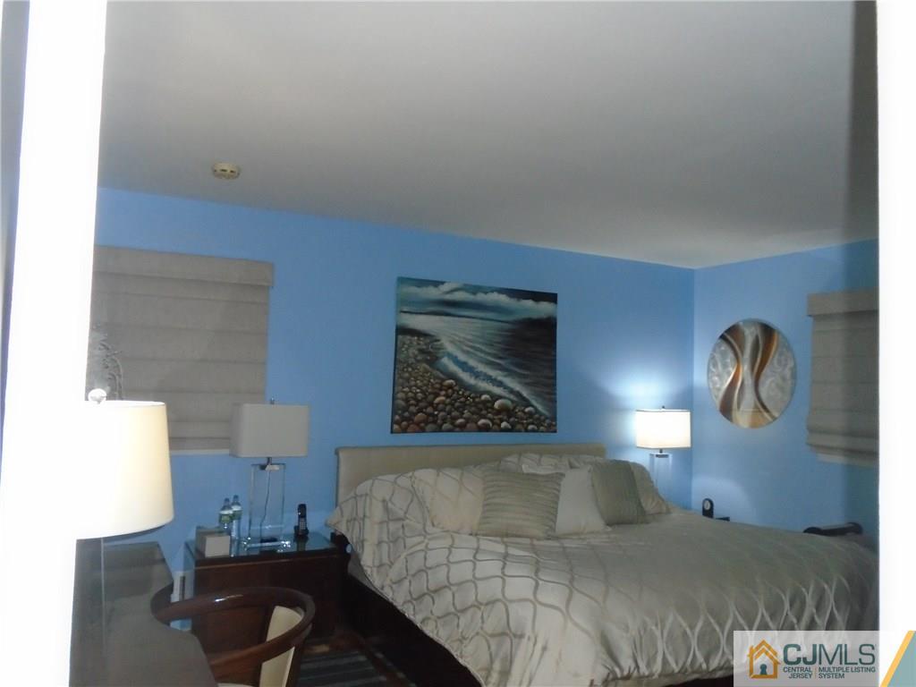 69 Harmon Road Edison, NJ 08837 - Photo 12 of 23 a bedroom with a bed and a lamp with the bookshelf