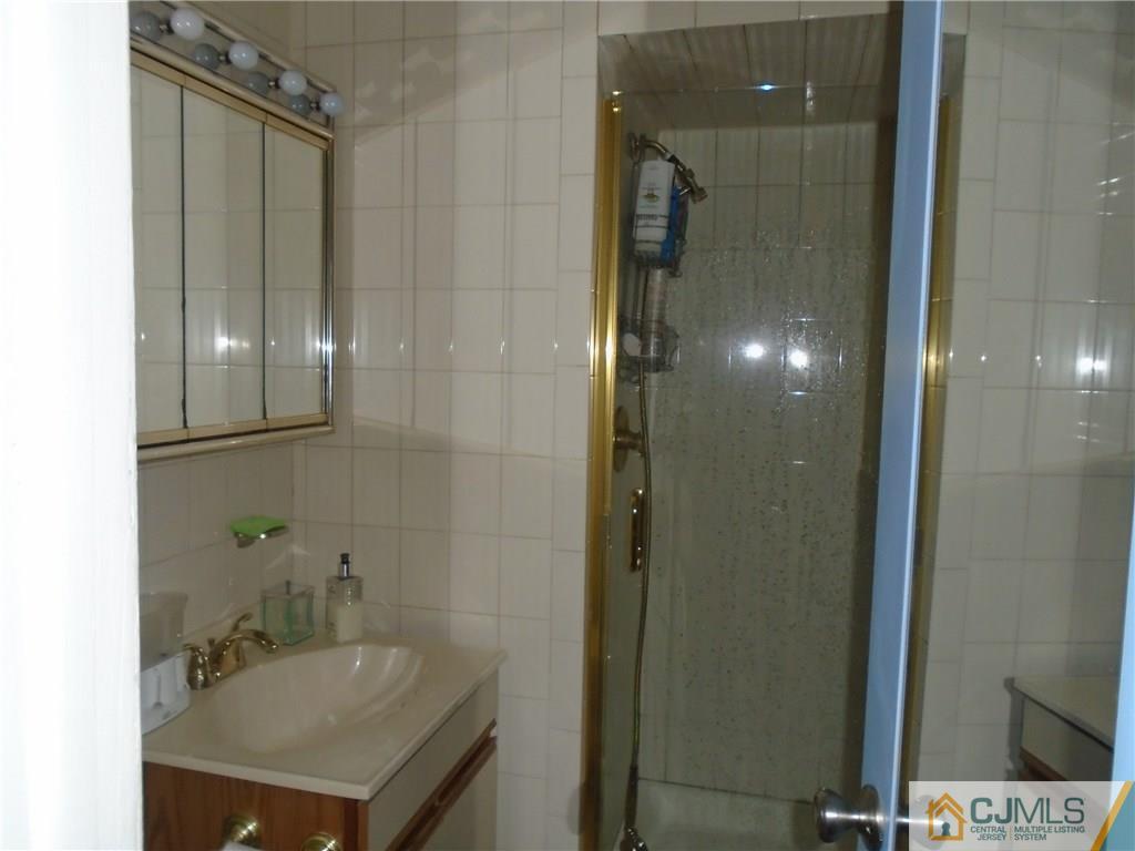 69 Harmon Road Edison, NJ 08837 - Photo 17 of 23 a bathroom with a sink a mirror and shower