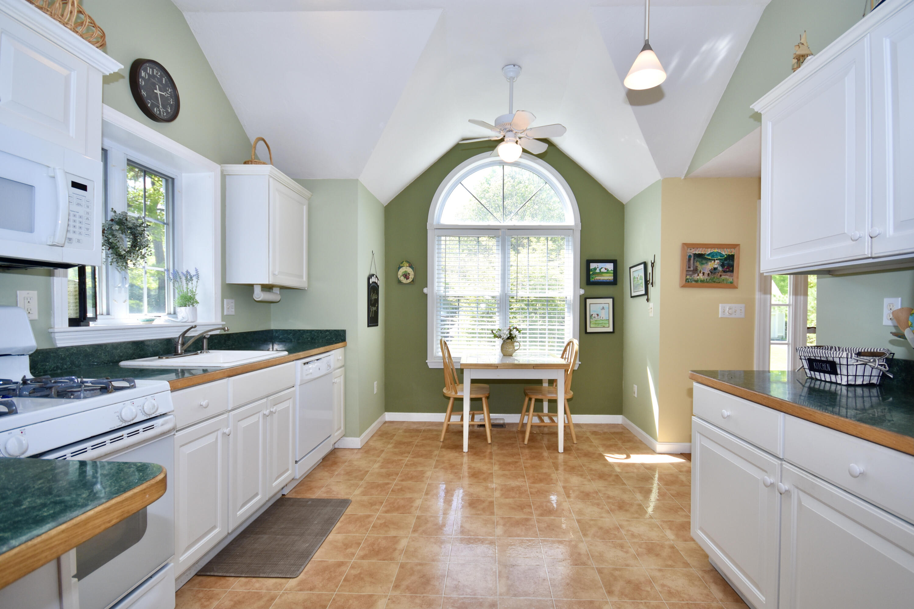 54 Snead Drive Mashpee, MA 02649 - Photo 12 of 32 a large kitchen with stainless steel appliances a stove a sink a window and a dining table