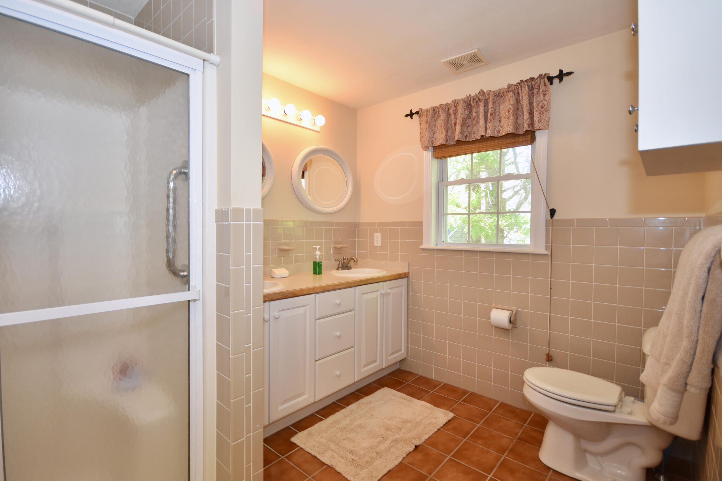54 Snead Drive Mashpee, MA 02649 - Photo 22 of 32 a bathroom with a sink a toilet and shower curtain