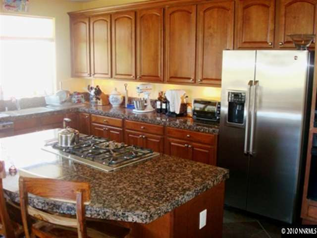7005 Cour Street Reno, NV 89511 - Photo 2 of 9 a kitchen with stainless steel appliances granite countertop a sink stove and refrigerator