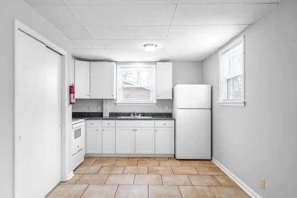 a kitchen with white cabinets and white appliances