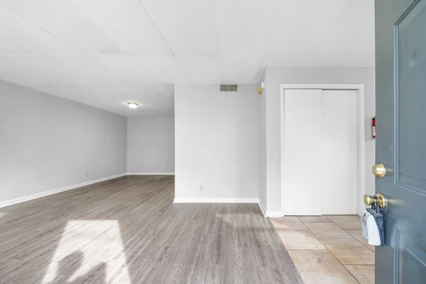 an empty room with wooden floor and sliding door