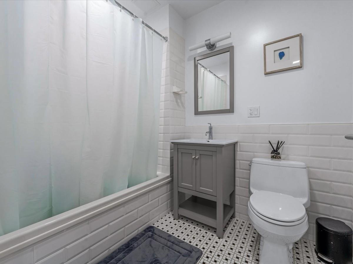 21-10 44th Drive, Unit 2B Queens, NY 11101 - Photo 11 of 19 a bathroom with a toilet a sink and shower