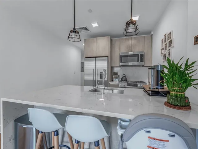 a kitchen with stainless steel appliances granite countertop a refrigerator and a stove