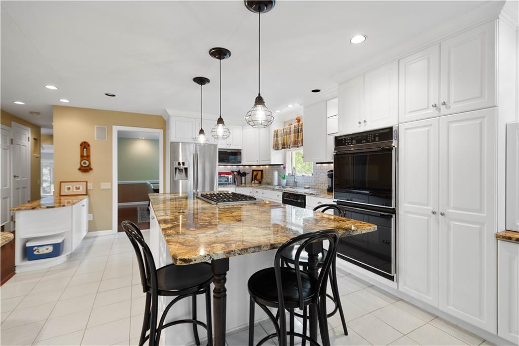 1580 Williamsburg Road Pittsburgh, PA 15243 - Photo 13 of 41 a kitchen with stainless steel appliances kitchen island granite countertop a table chairs and a refrigerator