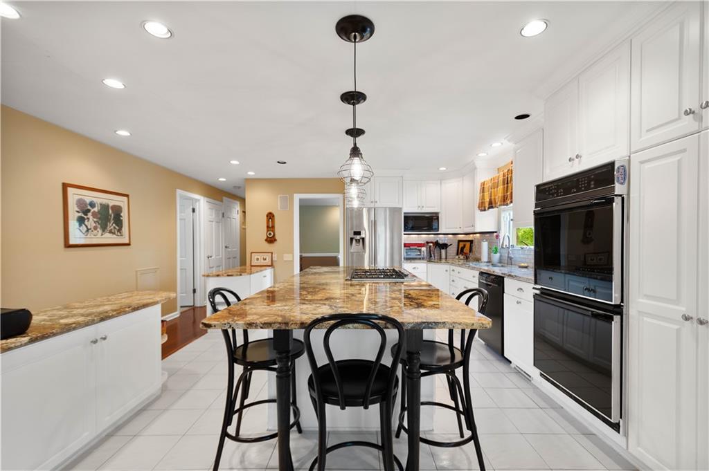 1580 Williamsburg Road Pittsburgh, PA 15243 - Photo 10 of 41 a kitchen with a dining table chairs stainless steel appliances and cabinets