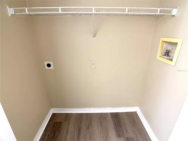 a view of a room with wooden floor and small window