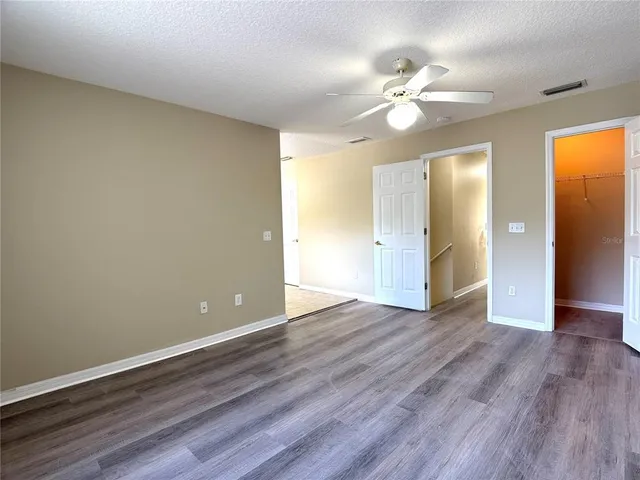 a view of a livingroom with wooden floor and a ceiling fan